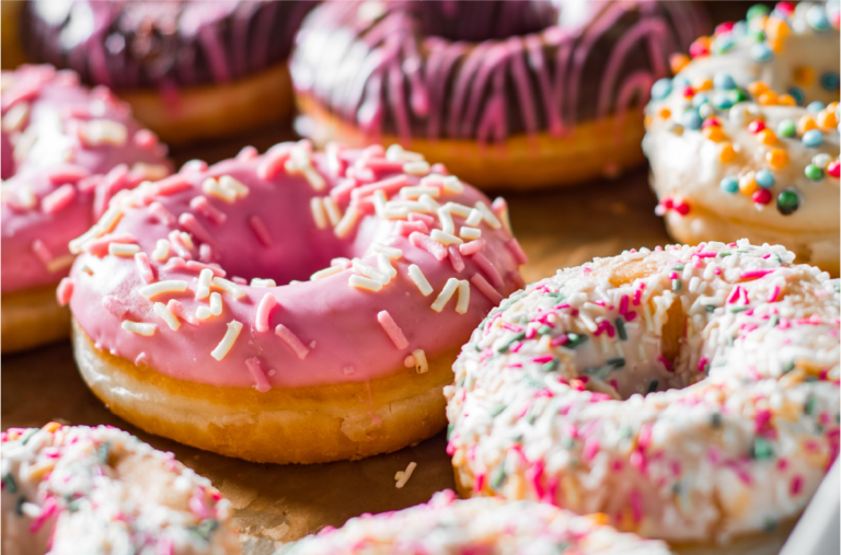 Donuts mit Zuckerguss, Schokoladenglasur und bunten Streuseln.