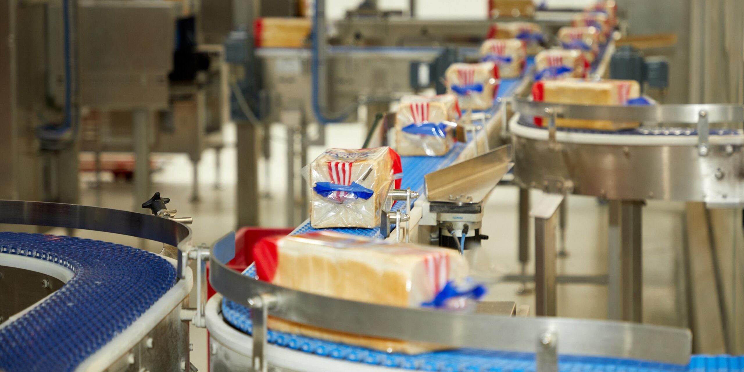 Förderband in einer industrillen Grobäckerei auf der verpacktes Toastbrot der Marke Sammy von Harry transportiert wird.