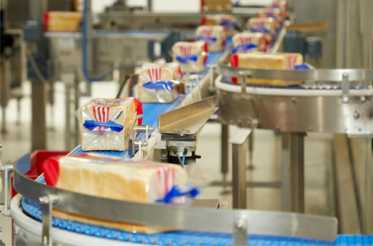 Förderband in einer industrillen Grobäckerei auf der verpacktes Toastbrot der Marke Sammy von Harry transportiert wird.