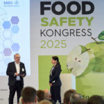 Hanno Bender und Prof. Dr. Tanja Schwerdtle stehen auf dem Food Safety Kongress 2025 auf der Bühne und diskutieren