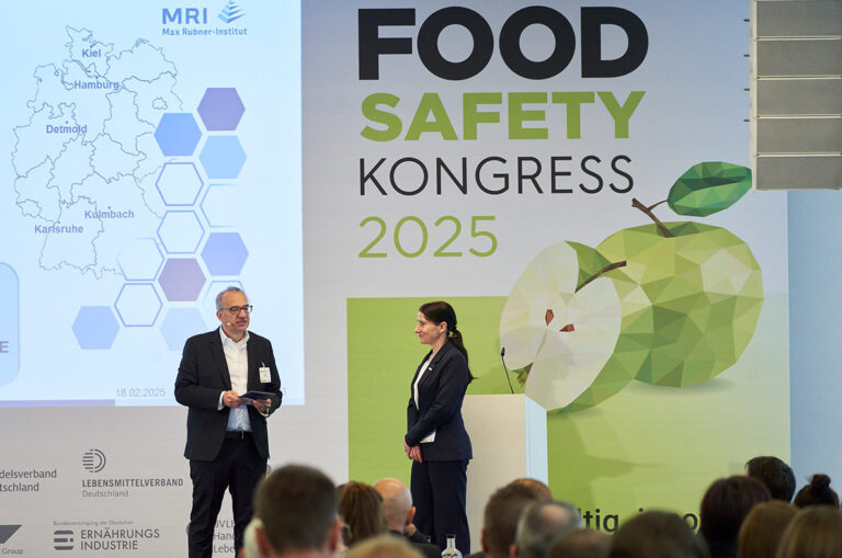 Hanno Bender und Prof. Dr. Tanja Schwerdtle stehen auf dem Food Safety Kongress 2025 auf der Bühne und diskutieren